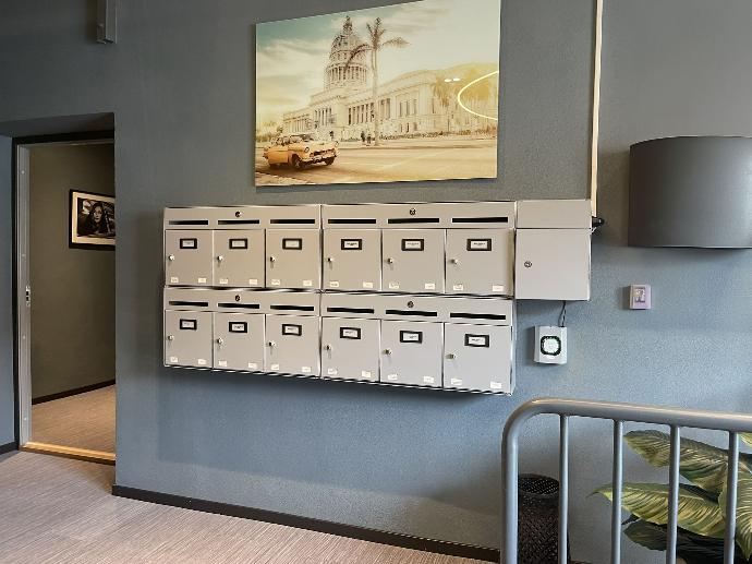 Innendørs postkasser med elektroniske låser og navneskilt, vegglampe, veggbilde FOTO