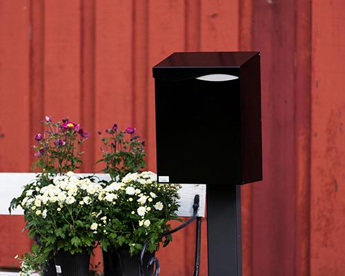 Villa Formfin postkasse grå, rød vegg, blomster FOTO